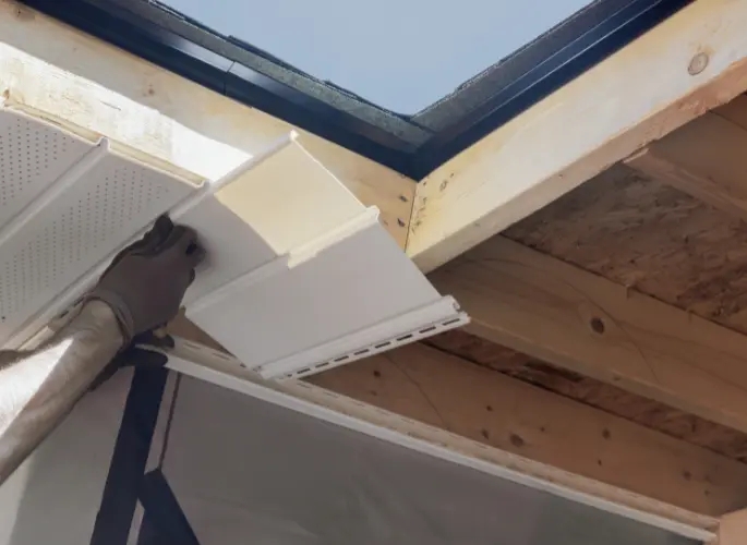A construction professional installs soffit.
