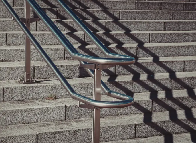 A metal handrail runs down a staircase.