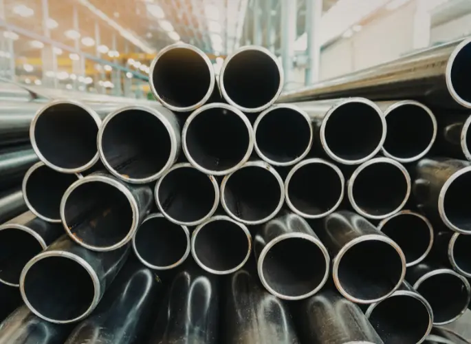 Several lengths of metal piping rest in a pile.