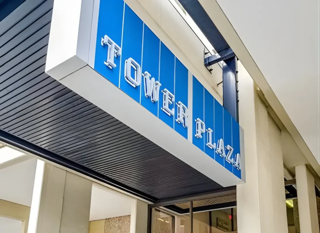 White metal letters on a blue background read, "Tower Plaza."