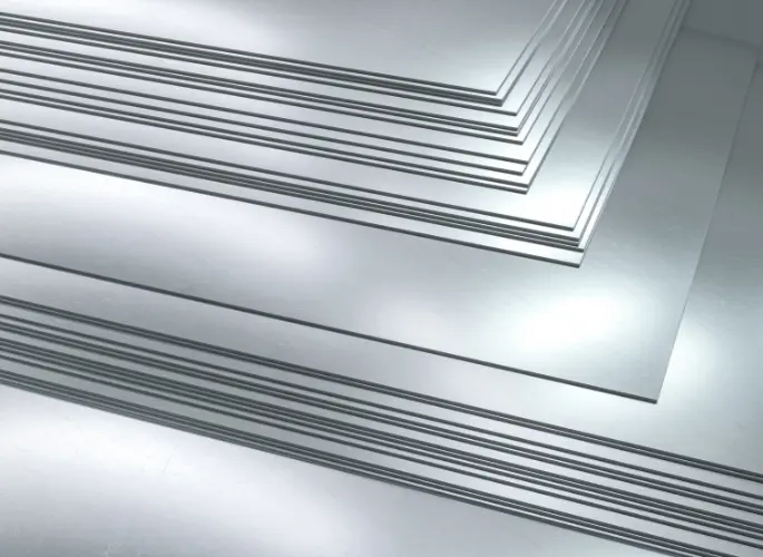 Several metal sheets rest in a pile.