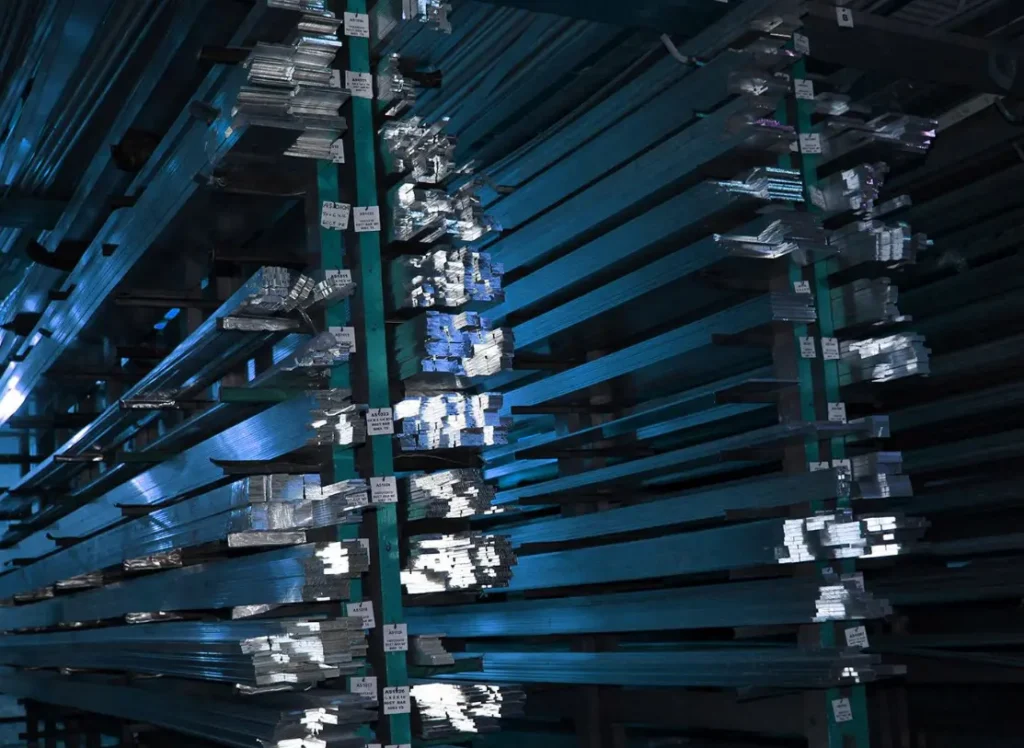 Several metal extrusions sit on shelves at Aluminum Supply Company.