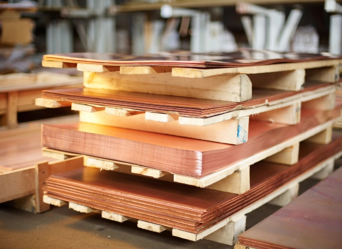 Several piles of copper sheets in a warehouse