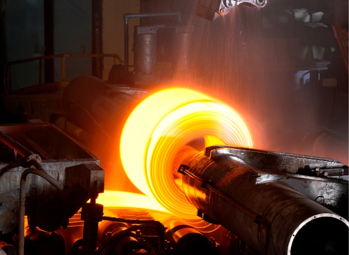 Glowing hot steel is rolled into a coil.
