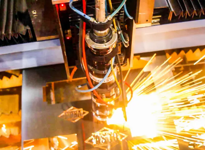 A laser cuts the ASCO logo out of a sheet of metal.