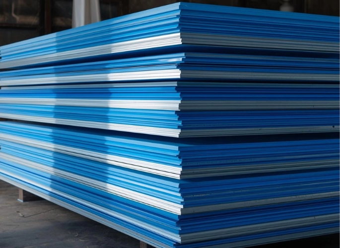 A stack of blue and white painted aluminum sheets